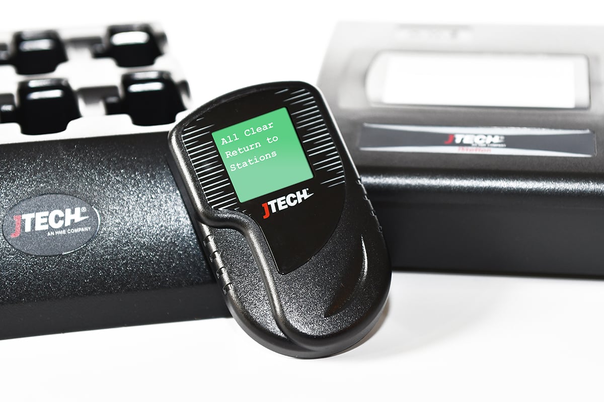Pager Closeup with Faded Transmitter and Charger - Green - All Clear Return to Stations Small